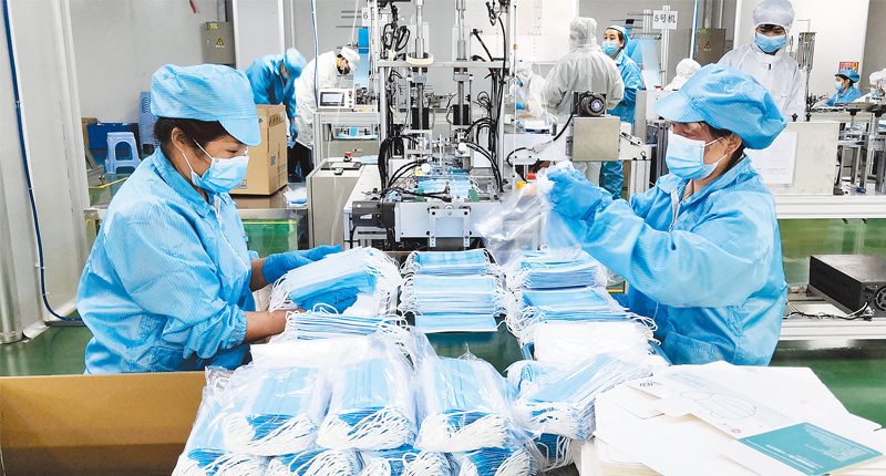 3月2日,深圳一口罩工厂,工人在生产线上包装产品.(新华社)