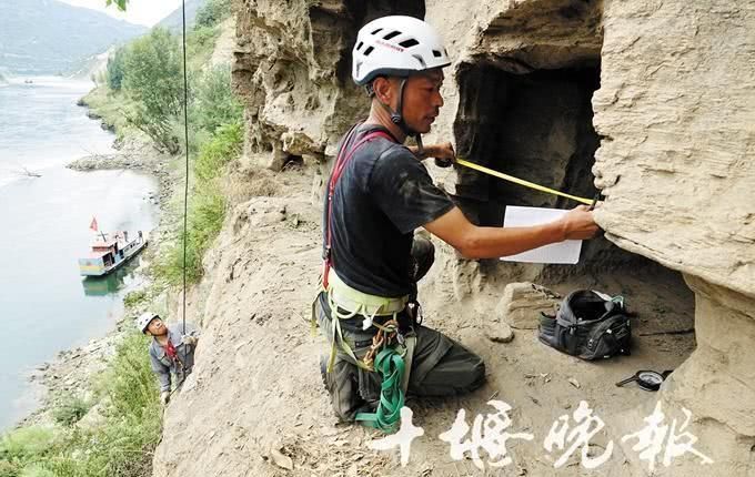 考古工作者在鄖西縣羊皮灘的懸崖峭壁上,探尋崖墓的祕密。(取自《十堰晚報》)