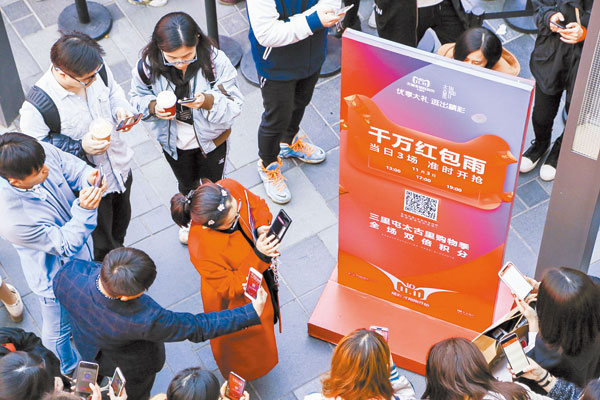 11月3日,天貓首輪雙11紅包雨降落在北京三裏屯太古裏,男女老少紛紛舉起手機掃碼「接雨」,現場信號幾乎癱瘓。 (取自微博@吃喝玩樂在北京)