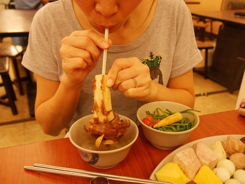 「一鍋羊肉」的羊大骨是人氣商品,滿滿的骨髓隨你吸,店家還貼心準備吸管讓你方便取用。(蔡依珍攝)