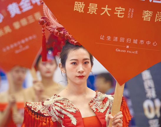 大陸房地產業內普遍認為,調控政策見底趨勢明顯。圖為山西一房地產交易展示會上,古裝美女銷售員舉牌推銷房屋。(中新社資料照片)