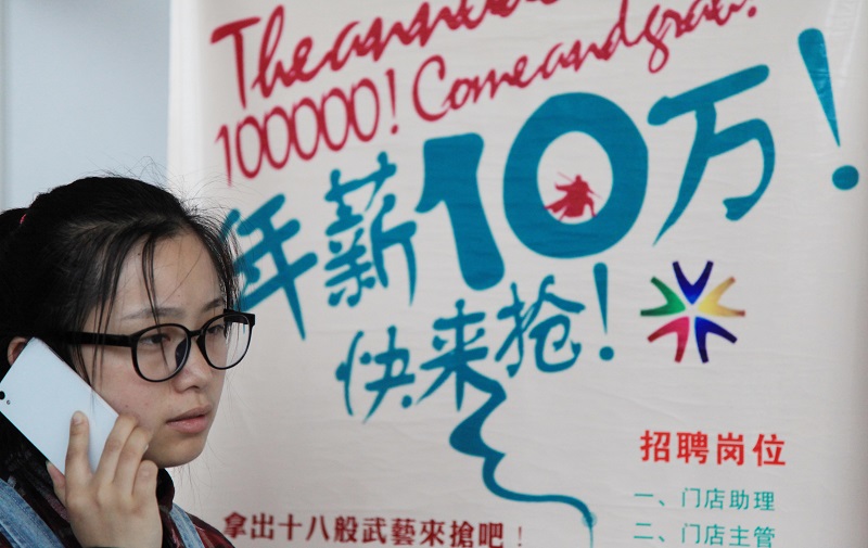 南京大學生專場招聘會,畢業生從招聘宣傳牌前經過。(新華社資料照片)