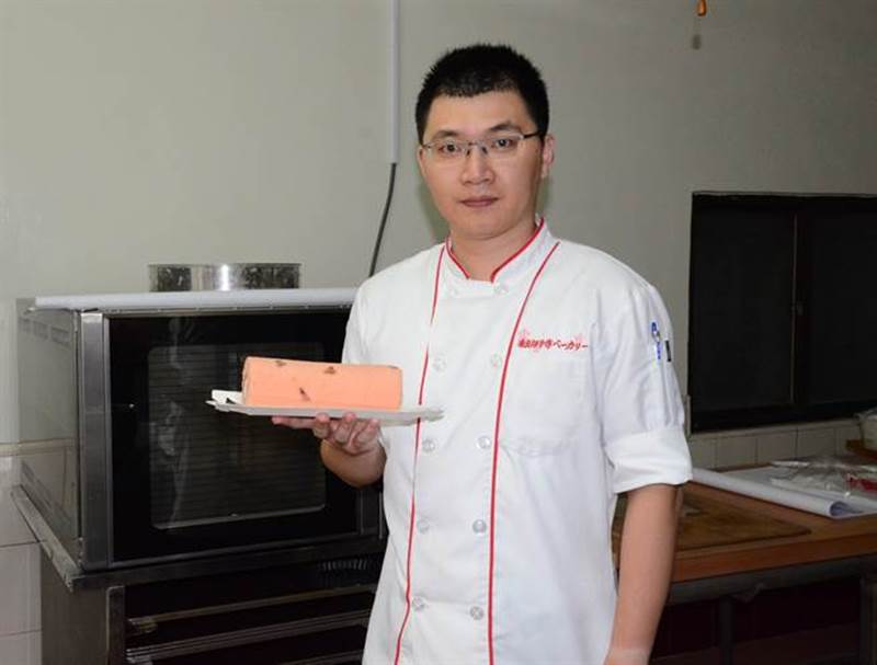 張家銘製作蛋糕遠近馳名,他手上端的是櫻花生乳捲。(林瑞益攝)