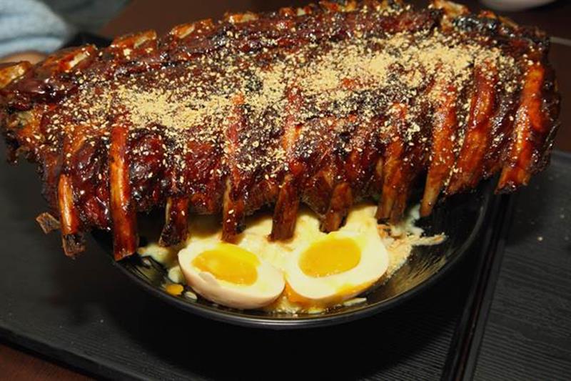 ㄨ麻尹日式蓋飯的招牌ㄨ魔爪肋排丼飯,被譽為地表最強,幾乎到半張桌子大的肋排讓人又驚又喜「超狂!」。(楊玉如攝)