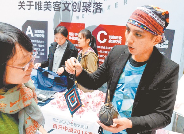 福州文創節上,一台灣青年創客向觀眾展示來自原住民的藝術品。(中新社資料照片)