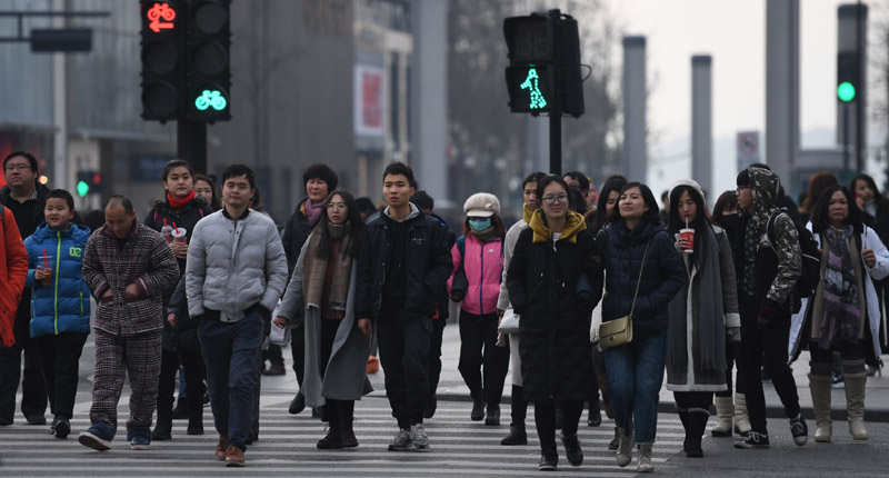 2018年2月1日,杭州街頭大量行人匆忙過馬路。(中新社)