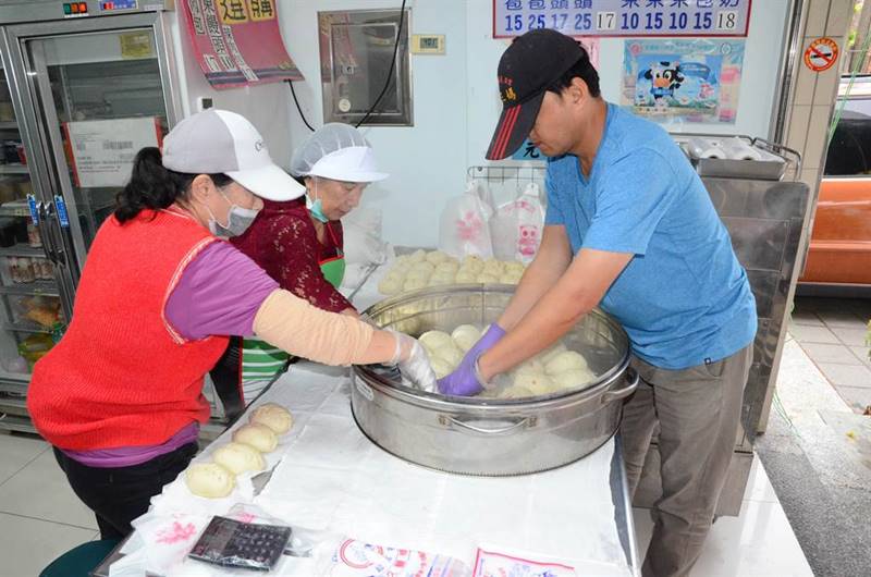 宏達包子店老闆與工作人員忙著處理剛出爐的包子。(林瑞益攝)