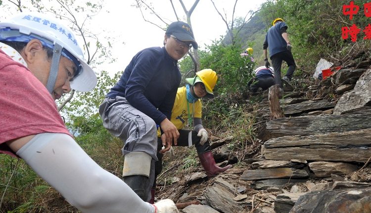 台灣千里步道協會副執行長徐銘謙（左二）教導志工如何做下邊坡砌石駁坎。（劉宗龍攝）