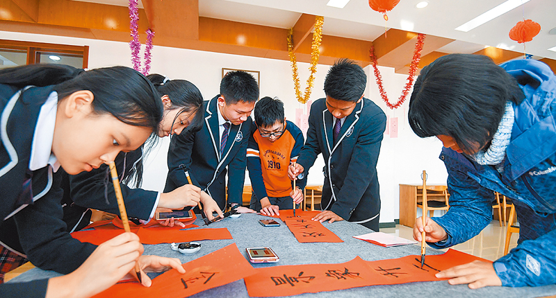 1月22日,台灣中學生來到北京市海淀實驗中學與大陸同學交流。圖為兩岸中學生在交流活動中一起寫春聯。(新華社)
