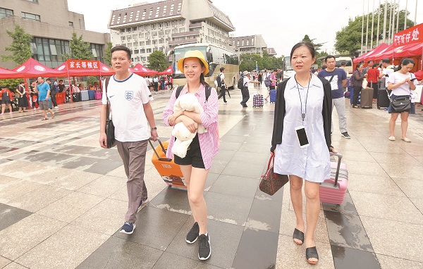一名大學新生在父母陪同下,開心地走在北京大學校園裡。(中新社資料照片)