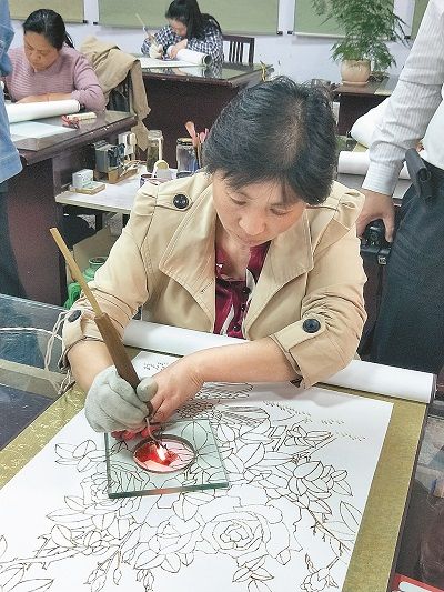大陸河南南陽的烙畫師,正用數百度高溫的鐵筆烙燙做畫。 (記者陳君碩攝)