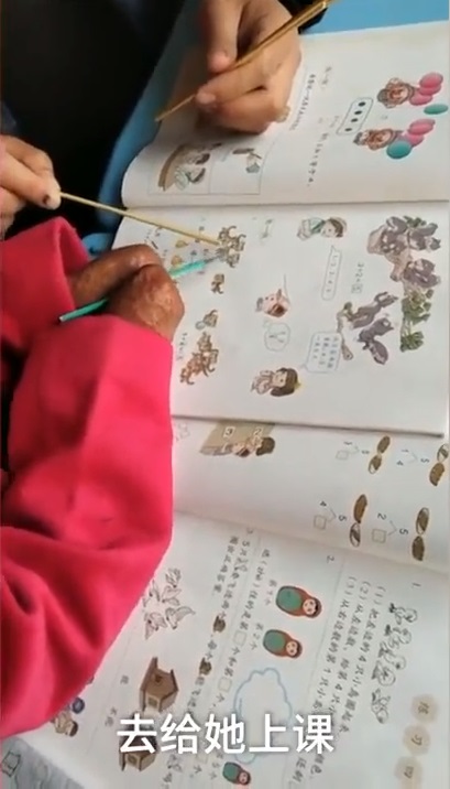 小芸努力靠兩隻「手」練習用鉛筆。(截自中國之聲)