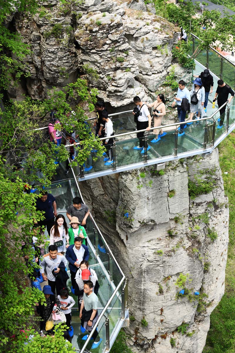 大批遊客4日前往山東葫蘆套村景區的環山玻璃棧道。(新華社)