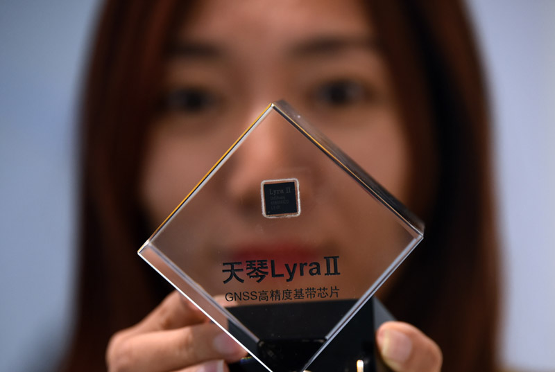 一名工作人員20日展示支持北斗三號民用導航訊號體系的「天琴二代」晶片。(中新社)