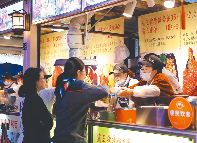 上海一夜市內,遊客在選購小吃。(新華社資料照片)