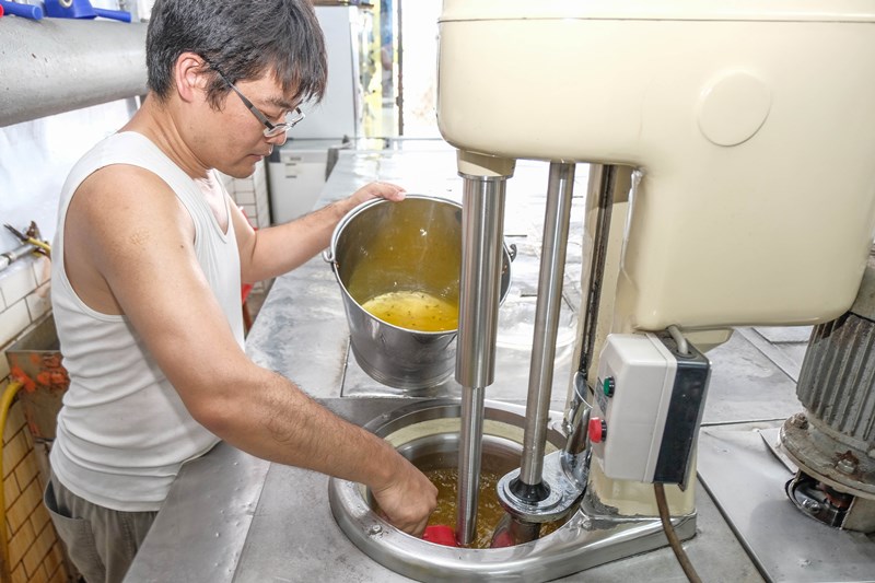張永彬忙著攪拌做百香果冰沙。(羅浚濱攝)