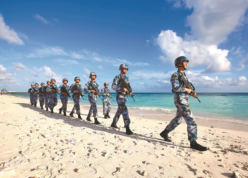 守衛在南沙群島永暑礁上的海軍官兵在沙灘上巡邏。(新華社資料照片)