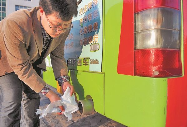 一名工作人員用紙巾展示液化天然氣公車的廢氣排放情況。(新華社資料照片)