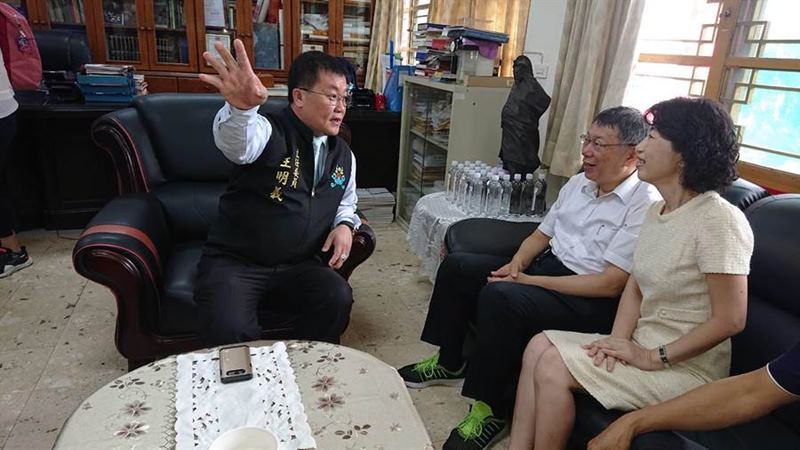 台北市長柯文哲(白襯身者)與夫人陳佩琪聽起聖母廟主委王明義說明廟史感到很有意思。(程炳璋攝)