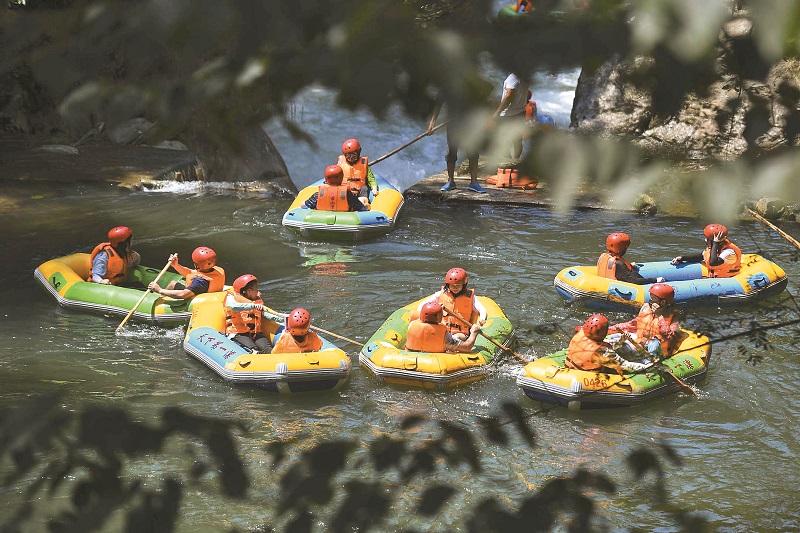8月5日,眾多遊人到平江連雲山的河道漂流避暑。(中新社)