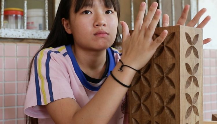 木工班學生鍾美貞看著她的「胖胖木」，表示希望有人會欣賞她的作品，如果能順利義賣出去，會有被肯定的感覺。（季志翔攝）
