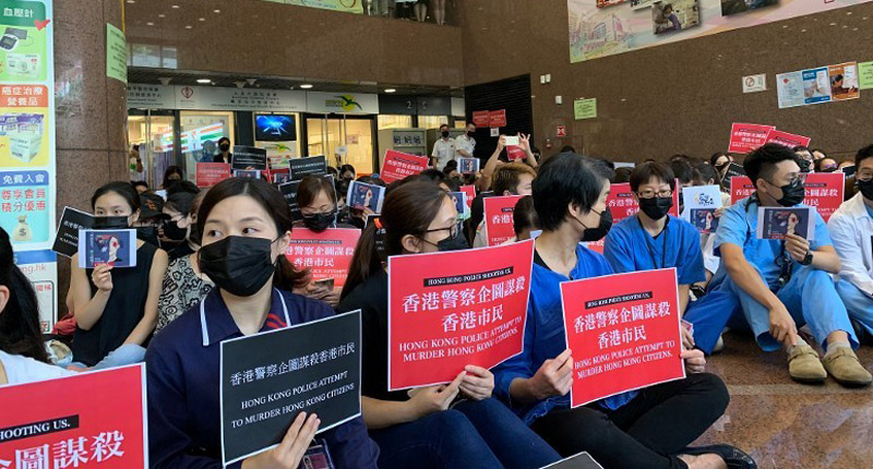 香港集會人士手持標語批評港警使用過分武力。(取自東網)