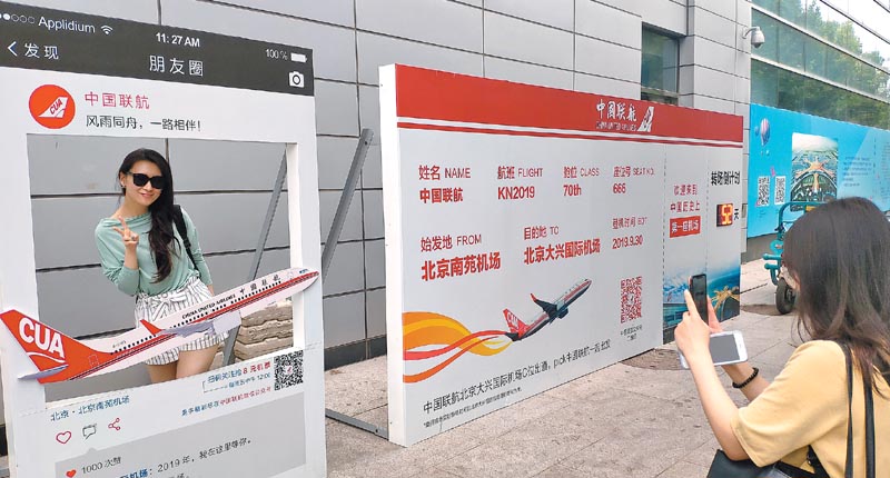 ▲8月9日,旅客在北京南苑機場候機樓外的倒計時牌前留影。(中新社)
