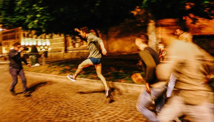 旁邊友人一直追著新郎嬉鬧，攝影師倒著跑步拍攝。