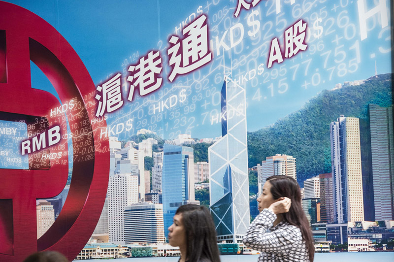 民眾從香港中環一家銀行的滬港通廣告牌前走過。(新華社資料照片)