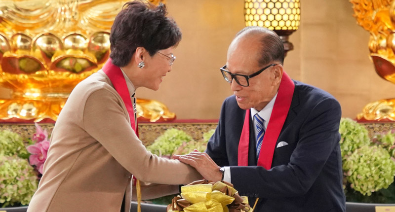 3月27日,香港特首林鄭月娥(左)與李嘉誠(右)握手致意。(中新社)