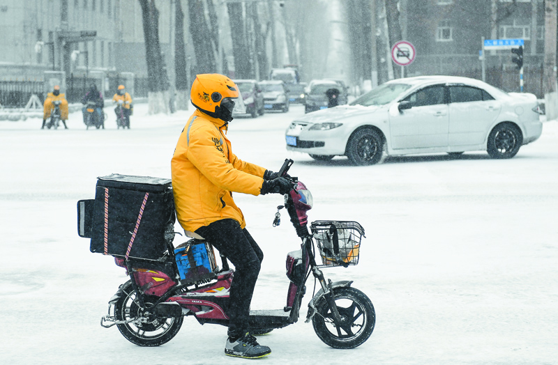 3月21日,在吉林長春,一名外賣員冒雪送餐。(新華社)