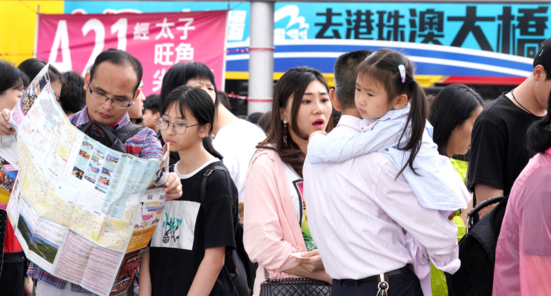 ▲眾多遊客在大橋香港口岸巴士站候車,準備前往市區。(中新社資料照片)
