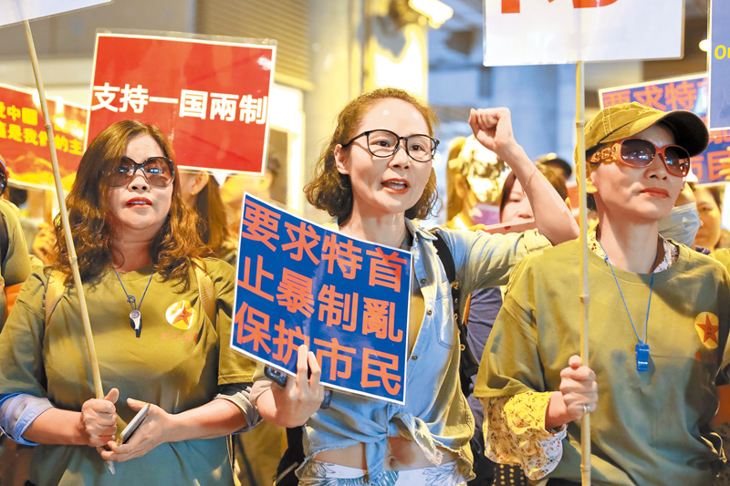 11月14日,香港市民在元朗舉行遊行集會,高舉「支持一國兩制」、「要求特首止暴制亂保護市民」等標語。(中新社)