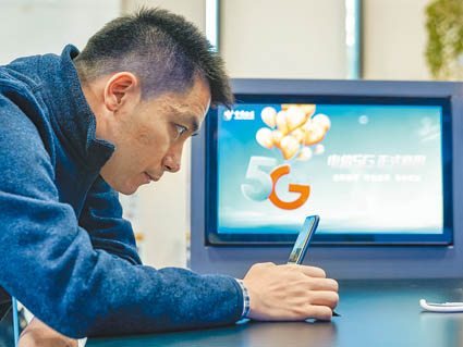 ▲北京中國電信營業廳,消費者試用5G手機。(新華社資料照片)