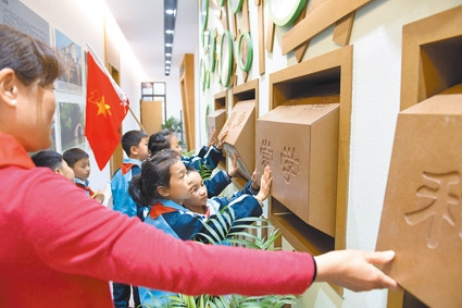 10月31日,志願者給浙江湖州市的八里店鎮常路學校小學生講解社會主義核心價值觀。(新華社)