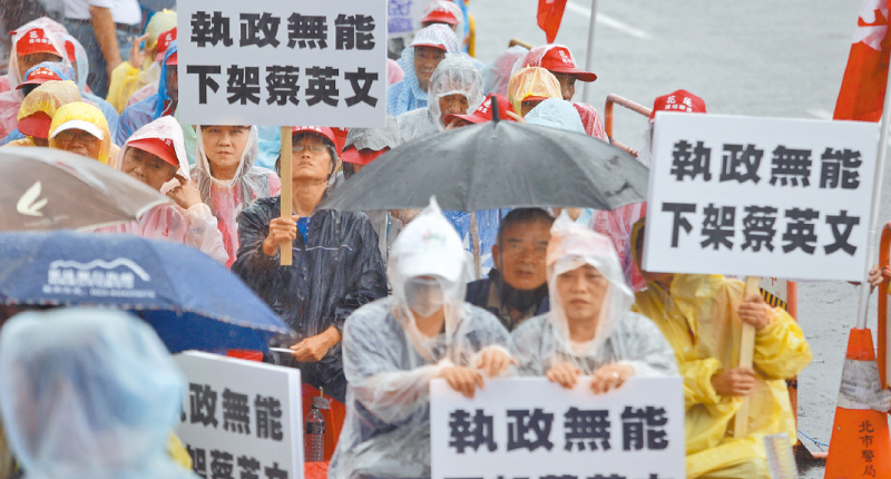 9月28日,由藍天行動聯盟等團體發起的「庶民自救大會」,民眾穿著國旗裝、手持標語,不畏風雨參與。(本報系資料照片)