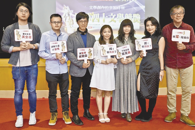 「旺旺‧時報文學獎」頒獎典禮,得獎者們拿手舉牌,開心合影。(劉宗龍攝)