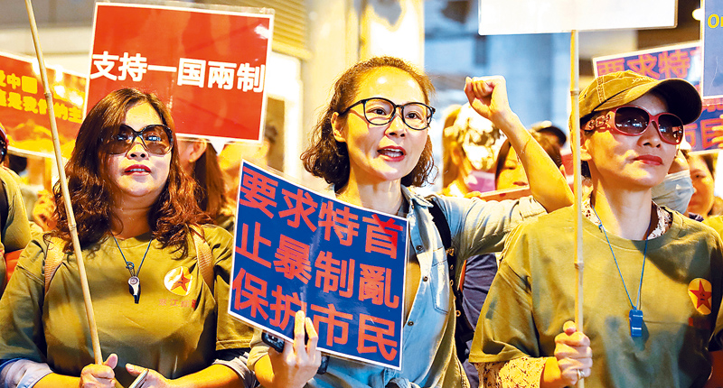 11月14日,逾百香港市民在元朗舉行集會,高舉「支持一國兩制」等標語。(中新社)