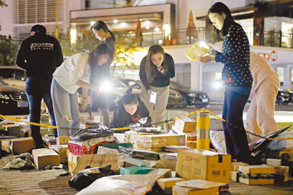 ▲大陸網購已成生活常態,圖為11月15日晚,上海虹橋樂賢居人才公寓民眾在小區廣場上收取快遞。(中新社)