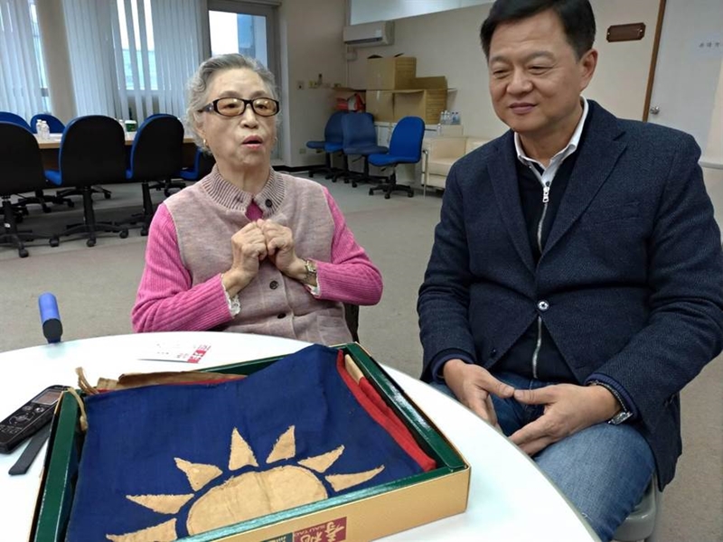 畢重英老太太向周錫瑋訴說國旗的故事。(黃福其攝)