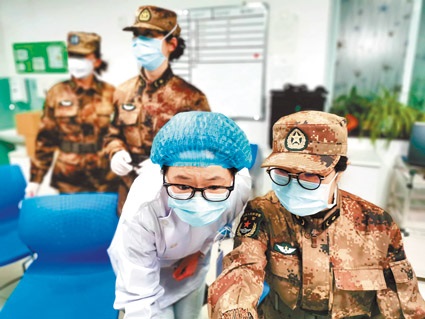 1月26日,解放軍陸軍軍醫大學醫療隊成員與武漢金銀潭醫院醫護人員,進行工作交接。(新華社)