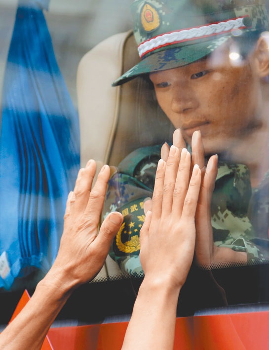廣西柳州一名新兵準備前往軍營,依依不捨望著窗外的家人。(新華社資料照片)