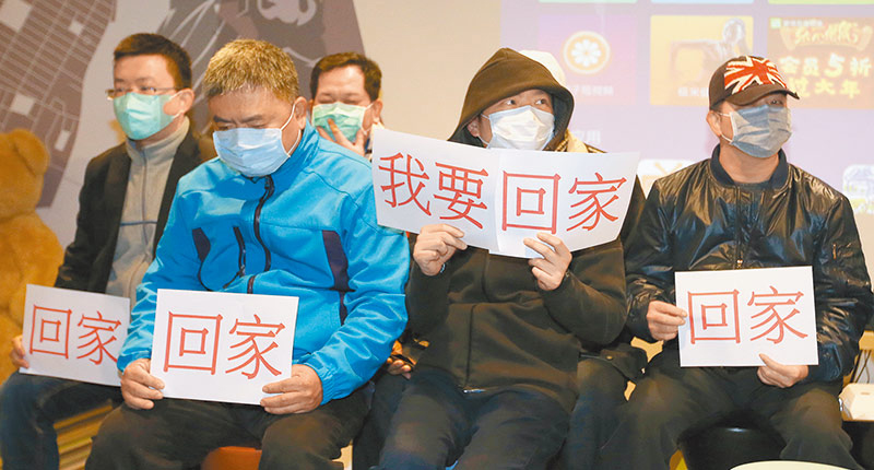 2月1日,滯留武漢民眾在台家屬手拿「回家」標語向外界求助。(本報系資料照片)