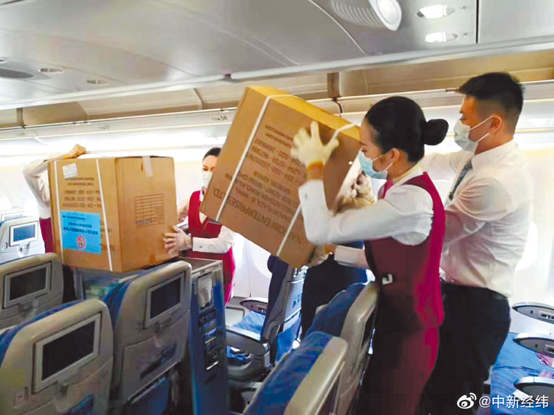 機長及空姐正在搬運一箱箱口罩。 (取自新浪微博@中新經緯)
