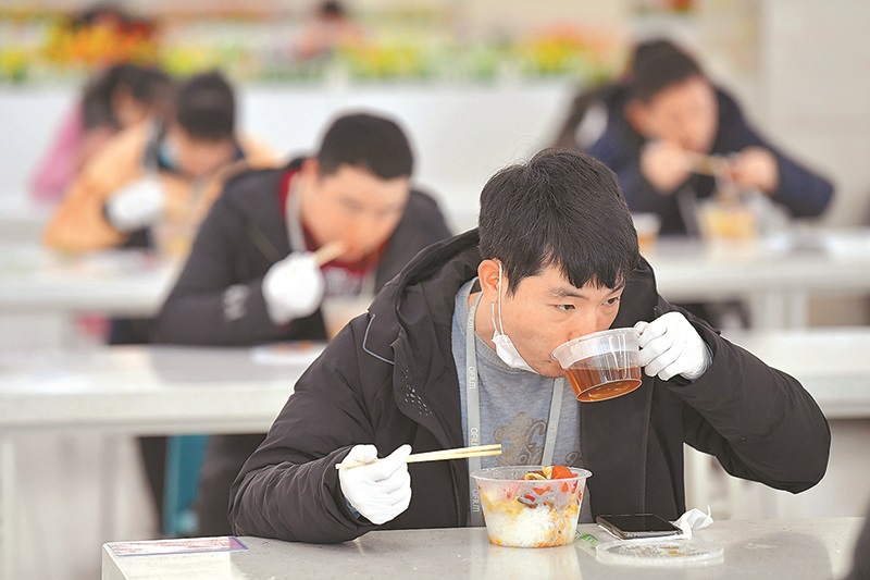 2月14日,南昌某企業員工在餐廳分桌用餐。(新華社)