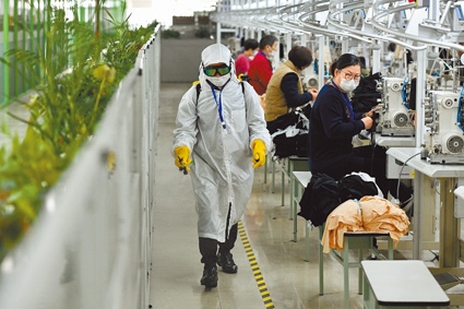 2月20日,福建晉江市一服飾公司員工對生產區域進行消毒。(新華社)