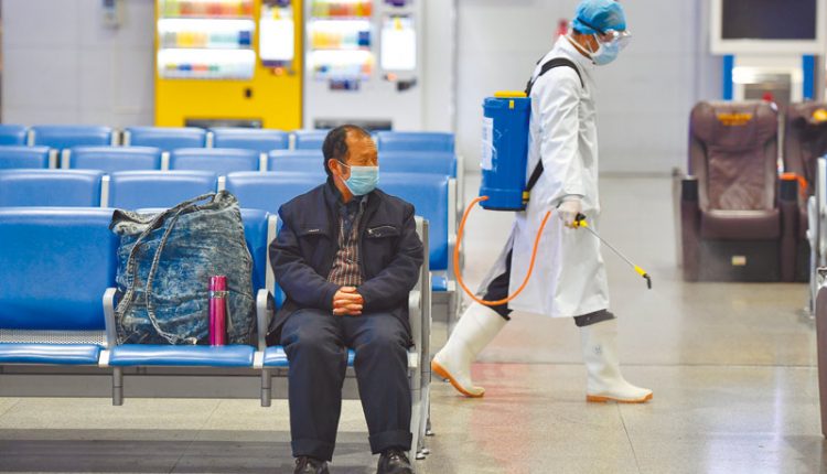 2月4日，昆明火車站候車旅客寥寥無幾，醫務人員在候車大廳進行消毒。（中新社）