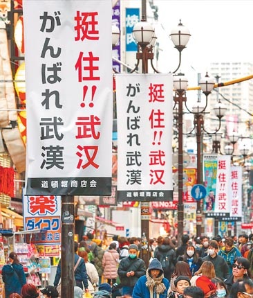 2月10日,日本大阪道頓堀商圈的街道上,掛著中日雙語的「挺住!武漢」標語。(新華社)