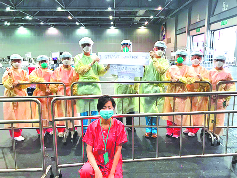▲醫護人員發起行動,高舉「為了你,我堅守崗位;為了我,請你堅守在家」字句拍照,香港醫護日前也響應。(取自新浪微博@香港文匯網)