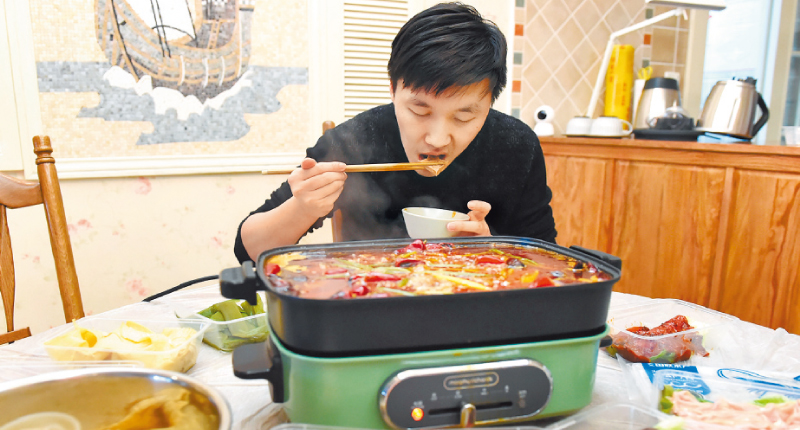 ▲疫情防控期間,透過互聯網平台點餐,重慶市民品嚐火鍋外賣。(中新社資料照片)
